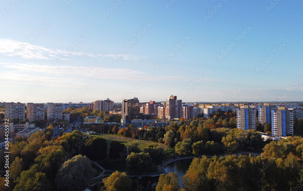 Fototapeta premium Top view of a beautiful autumn park in the city with houses