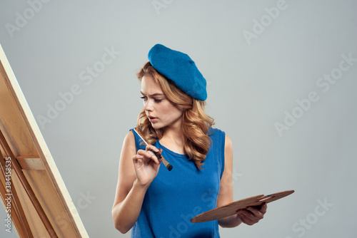 woman artist blue beret palette drawing on easel art creativity light background © SHOTPRIME STUDIO