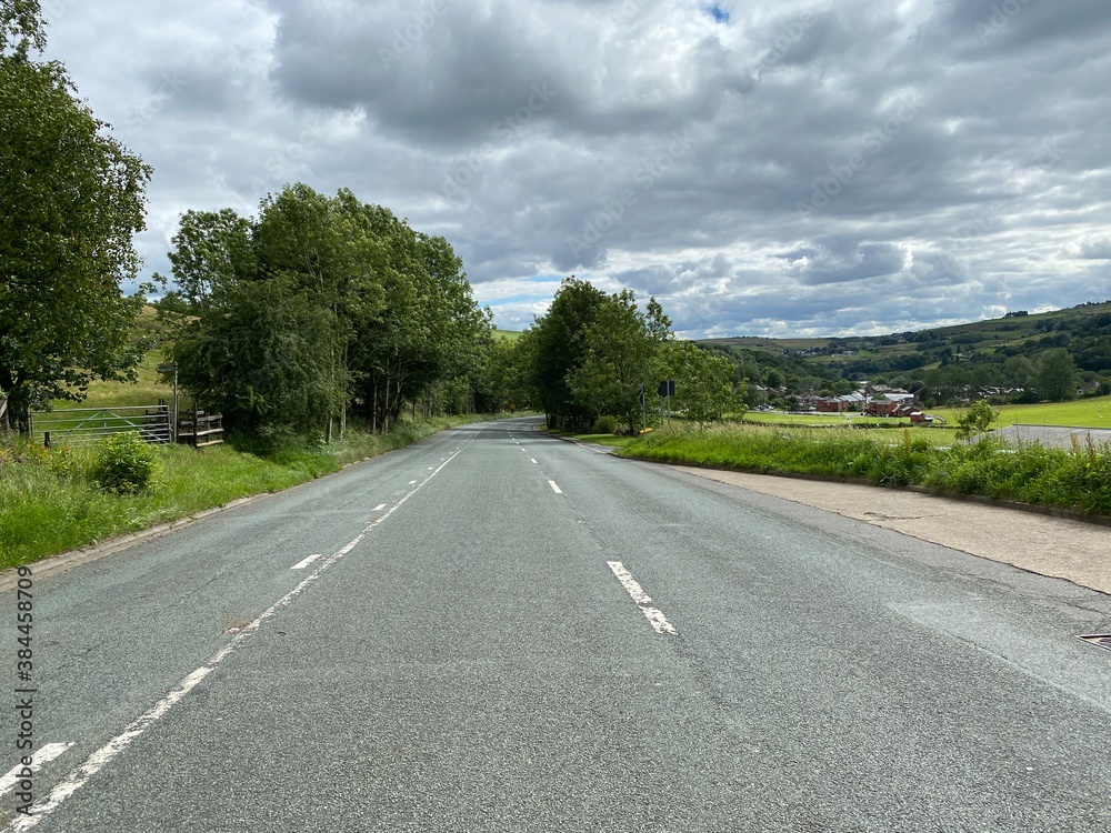 Looking down, Huddersfield road, with fields, trees, and buildings, on a cloudy day near, New Delph, Oldham, UK Looking down, Huddersfield road, with fields, trees, and buildings, on a cloudy day near, New Delph, Oldham, UK
