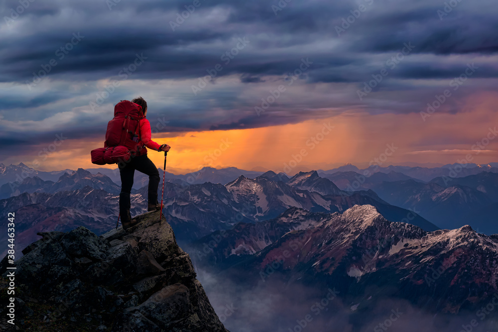 Girl Backpacker on top of a Mountain Peak. Dreamscape Artistic Render Composite. Aerial View. Landscape background from British Columbia, Canada. Golden Dramatic Sunset Sky.