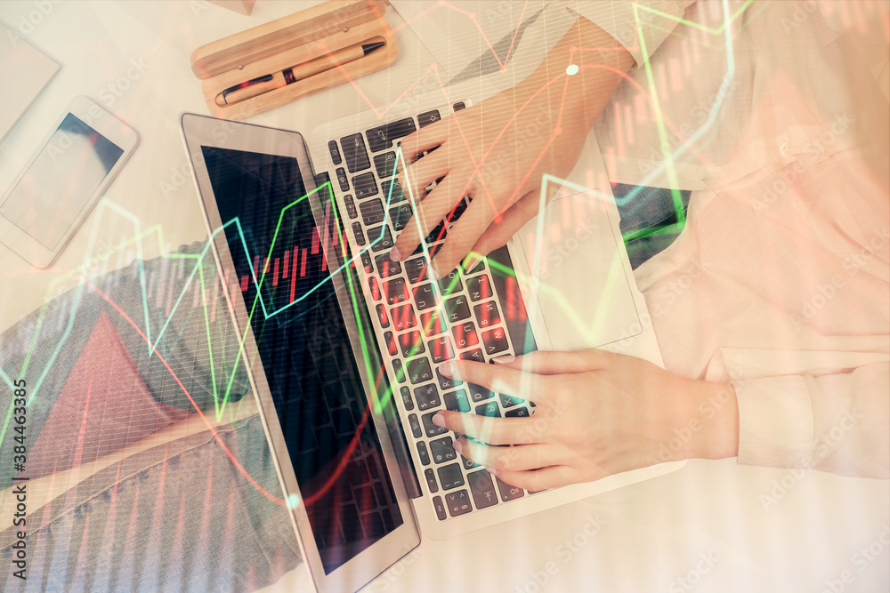 Double exposure of woman hands working on computer and forex graph hologram drawing. Top View. Financial analysis concept. Double exposure of woman hands working on computer and forex graph hologram drawing. Top View. Financial analysis concept.
