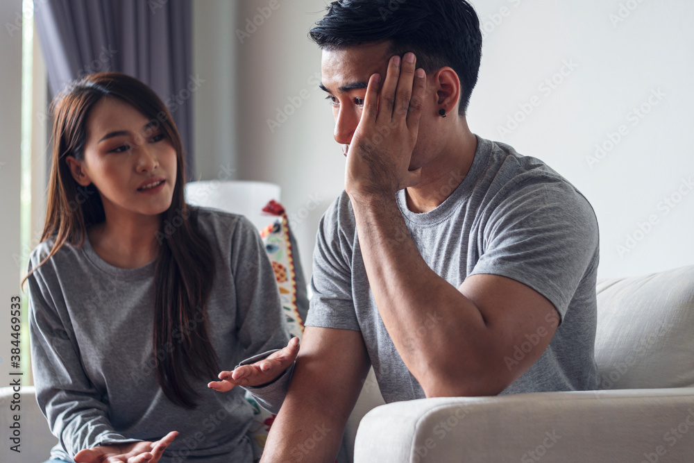 Obraz premium Unhappy young man have problems being quarrel with his wife sitting on sofa together at living room. Husband has attitude annoyed wife complained he very much. Couple problems in relationship concept.