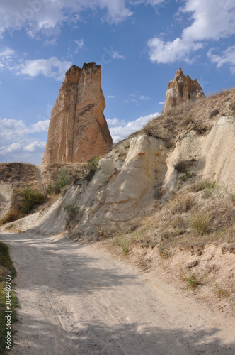 Scenic vertical view of a trail winding through the surreal landscape of Cappadocia, Turkey, on a cloudy day © Jen