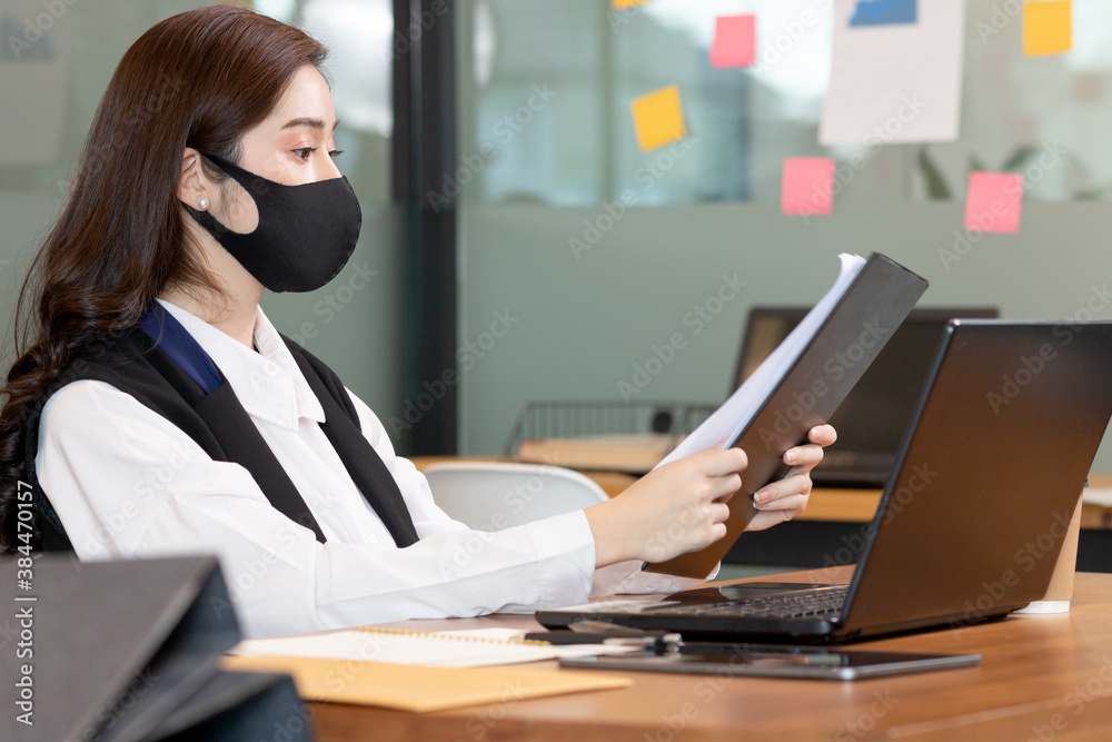 Business woman working job on labtop and wering mask in office. Business woman working job on labtop and wering mask in office.