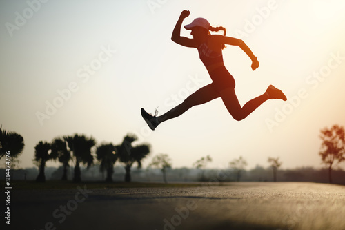 Silhouette young women jump on the road during sun rise