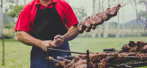 Man holding beef skewer on barbecue outdoors photo