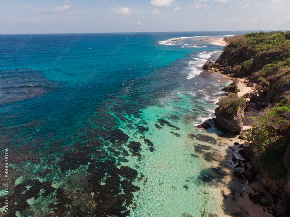 Top view aerial photo from flying drone of a beautiful sea scenery with coral bottom and white sand  beach with copy space
