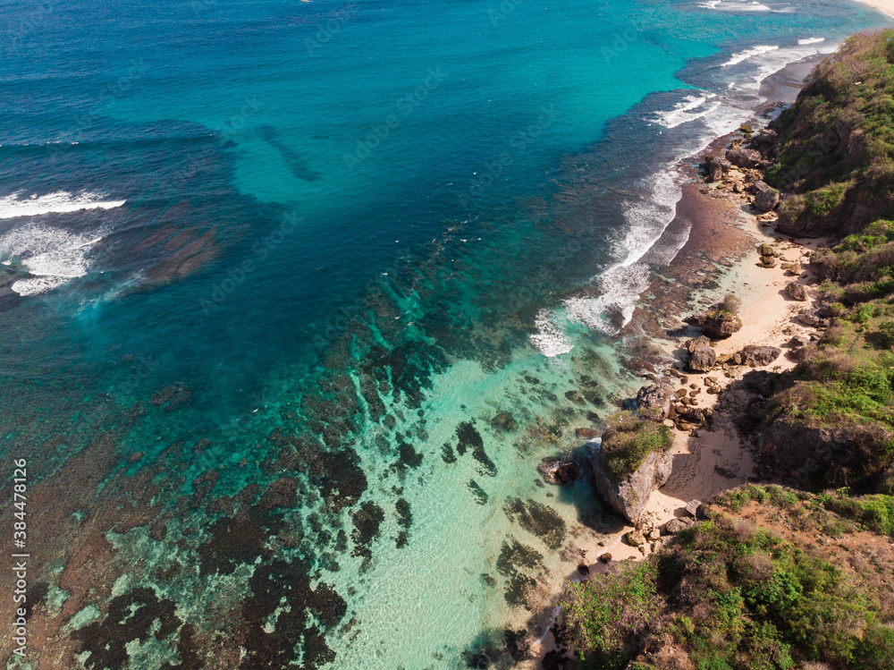 Obraz premium Top Aerial view from drone of impossible Beach in Bali, Indonesia. Clear blue aquamarine water during sunny day
