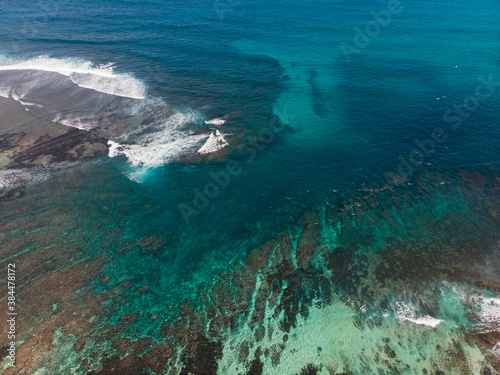 Top view from drone of beautiful coral reef beach. Clear blue aquamarine water during sunny day