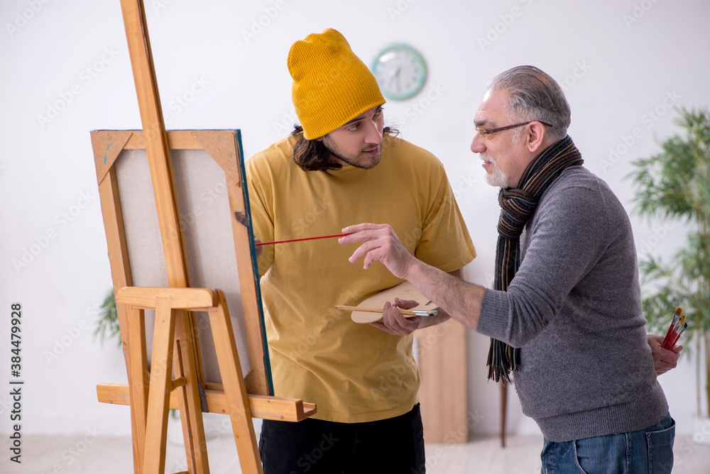 Old man taking lesson from young painter Old man taking lesson from young painter