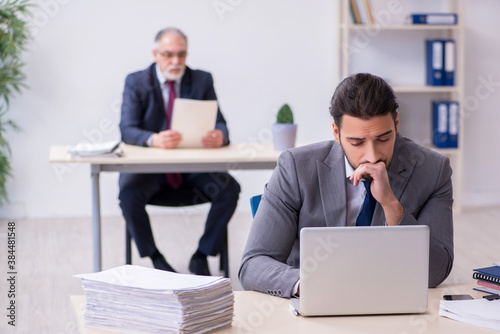 Old boss and his young assistant working in the office