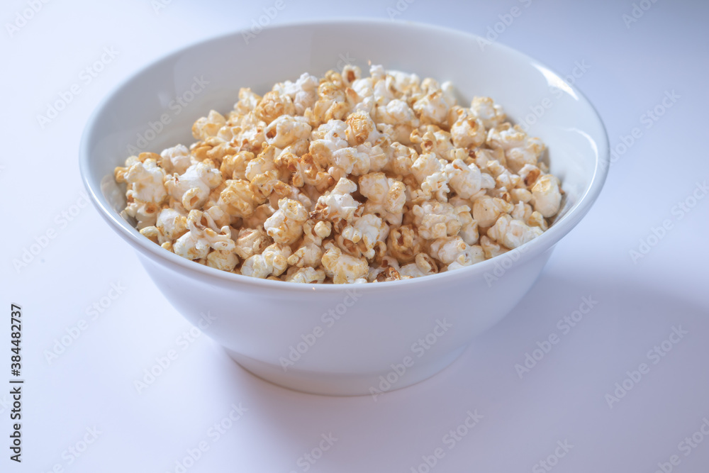 White bowl with sweet popcorn on white background