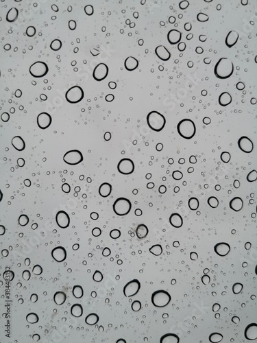 Abstract rain drops on clear stained glass.