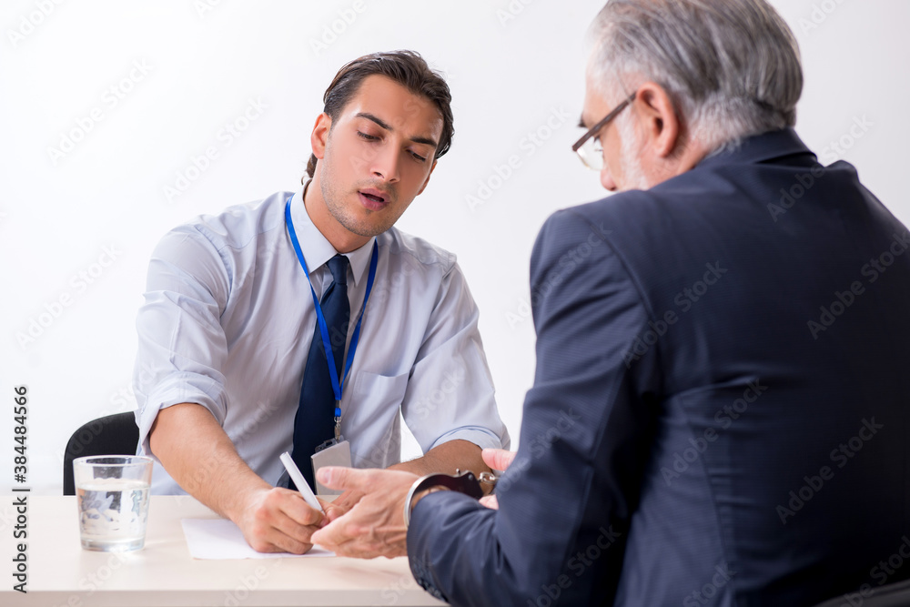 Old businessman meeting with advocate in pre-trial detention Old businessman meeting with advocate in pre-trial detention