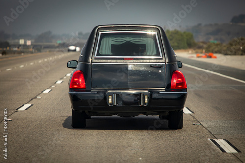 A black hearse driving down a freeway