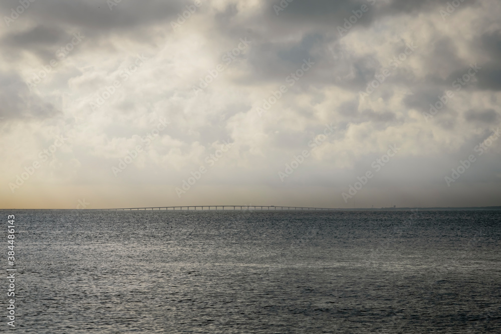 Clouds over the water of Pensacola Bay. View of distant Garcon Point bridge.