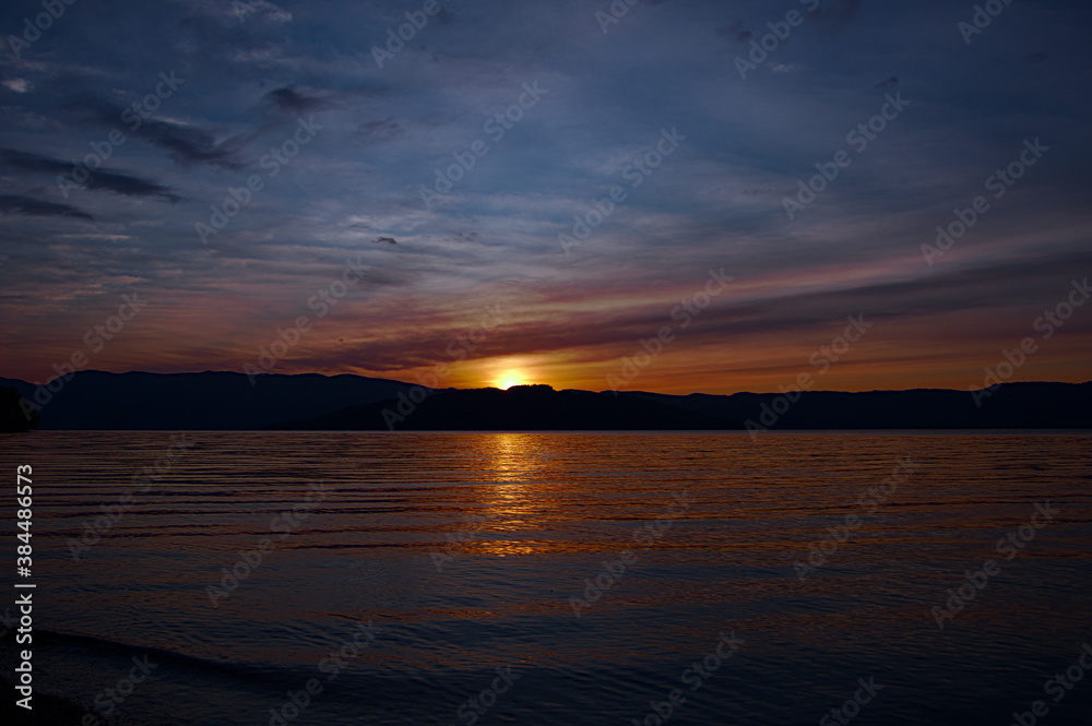 夕暮れの湖。徐々に暗くなって行く日没の風景。