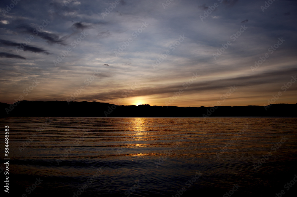 夕暮れの湖。徐々に暗くなって行く日没の風景。