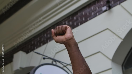 Raised African American male hand with clenched fist for protest against the background of the city street photo