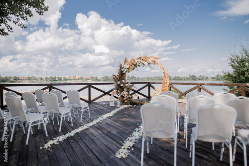 wedding round wooden arch with flowers on the pier