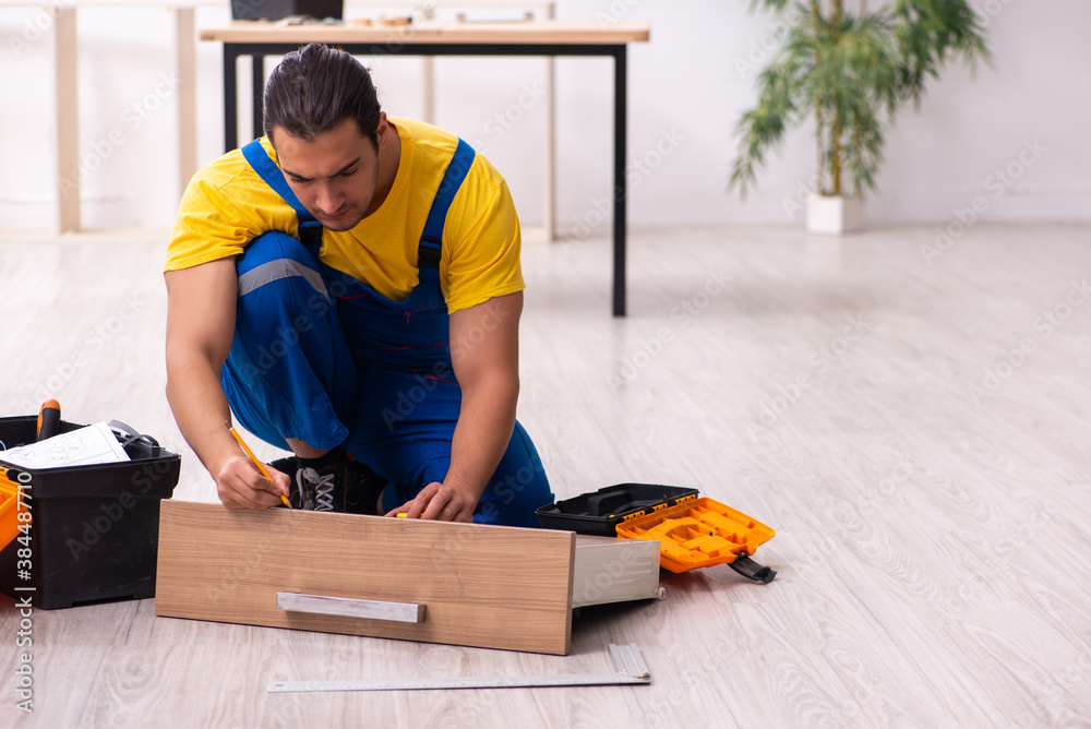 Young male carpenter working indoors Young male carpenter working indoors