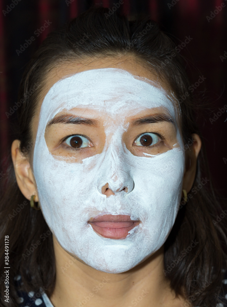 Fototapeta premium beautiful woman face white cream on black background