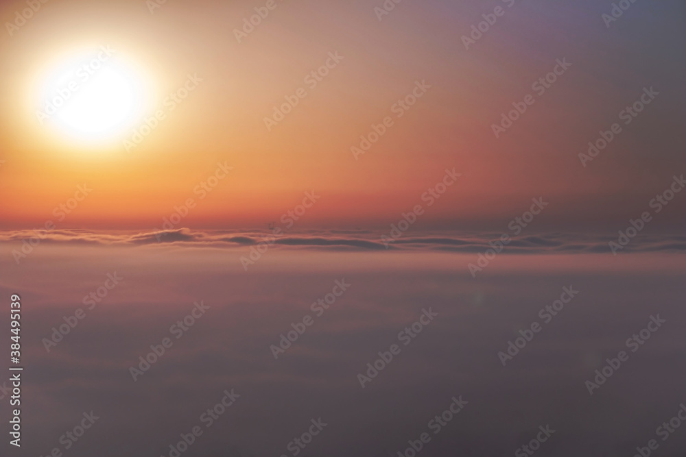 
Beautiful aerial view above clouds at sunrise. Fog above the city