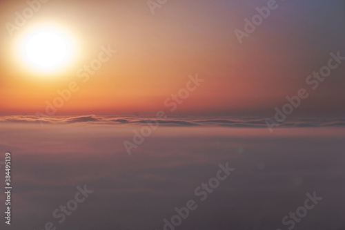  Beautiful aerial view above clouds at sunrise. Fog above the city
