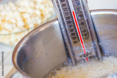 Sugar Thermometer at Soft Ball Stage in Silver Pot with Bubbling Hot Sugar Popcorn Bowl