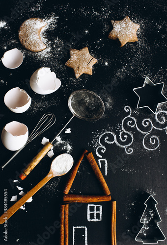 Cinnamon house on the table is complemented by a chalk pattern and utensils for making cookies.