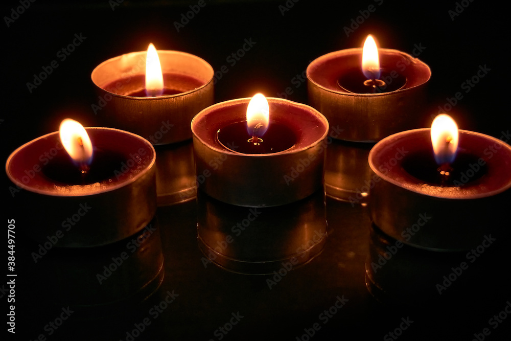 Burning candles on a black background, selective focus, romantic setting, romantic atmosphere, shot with shallow depth of field.