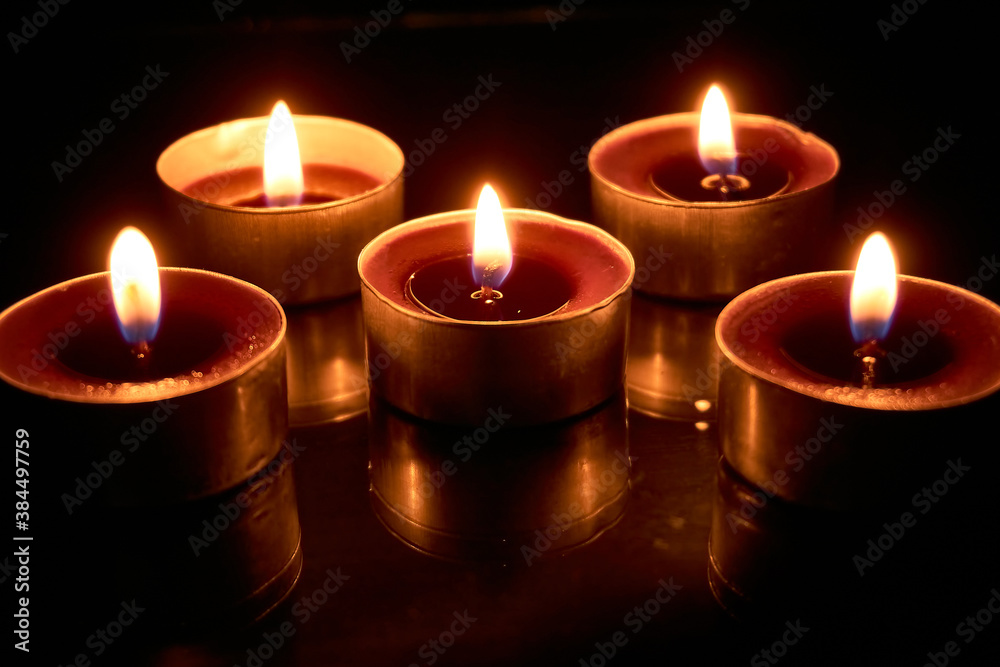 Burning candles on a black background, selective focus, romantic setting, romantic atmosphere, shot with shallow depth of field. Burning candles on a black background, selective focus, romantic setting, romantic atmosphere, shot with shallow depth of field.