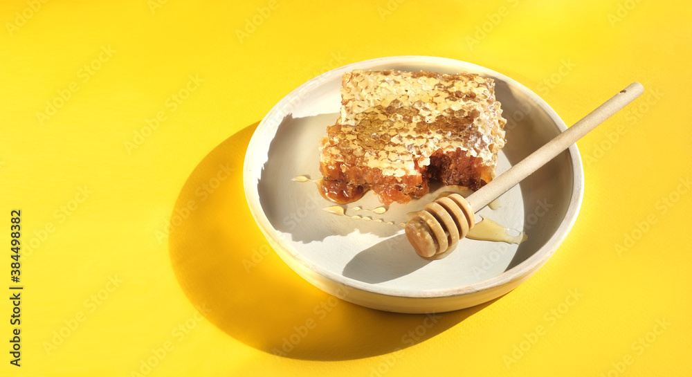 Honey comb with stick and plate banner in yellow background. Copy space. Honey comb with stick and plate banner in yellow background. Copy space.