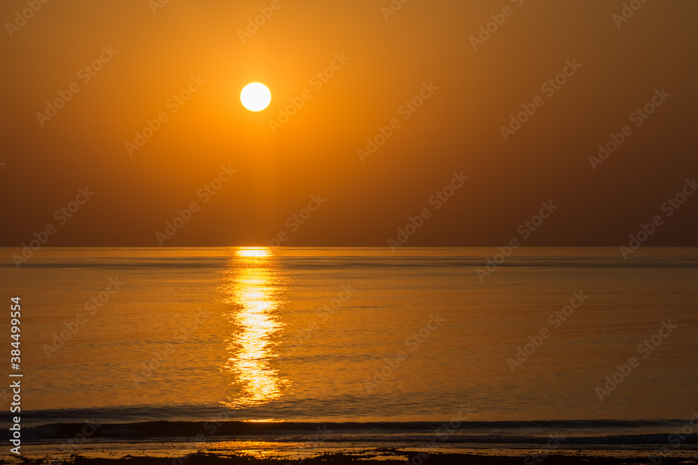 warm sunrise on the beach at the sea