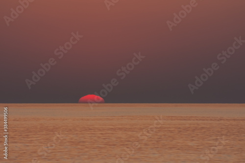 rising red sun at the horizon on the sea © thomaseder
