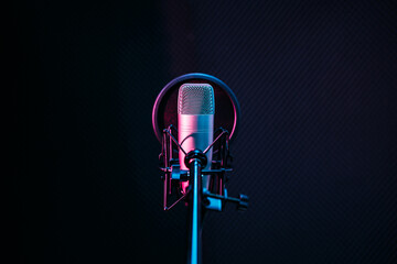 Studio microphone and pop shield on mic in the empty recording studio with copy space. Performance and show in the music business equipment.