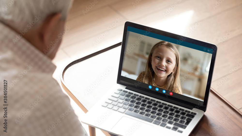 Close up rear view of elderly grandfather speak talk on video call on laptop with smiling small granddaughter. Mature grandparent have webcam digital conference with happy grandchild on computer. Close up rear view of elderly grandfather speak talk on video call on laptop with smiling small granddaughter. Mature grandparent have webcam digital conference with happy grandchild on computer.