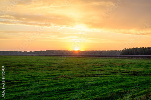 Photo of the evening sunset sky in autumn against the background of a green field