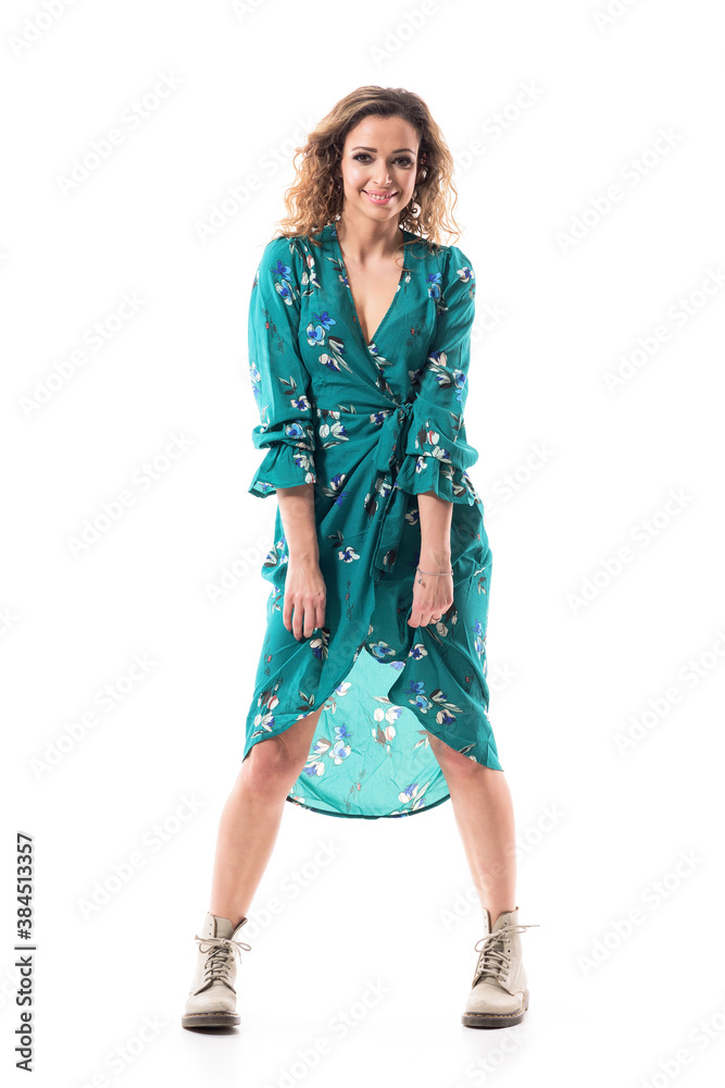 Happy playful cuddly cute young woman holding dress with windy hair. Full body portrait isolated on white background Happy playful cuddly cute young woman holding dress with windy hair. Full body portrait isolated on white background