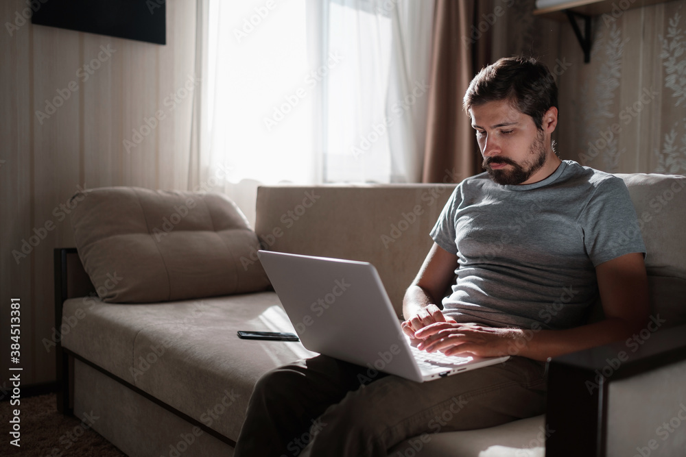 Remote Job. Man Working On Laptop Sitting On Sofa At Home. Remote Job. Man Working On Laptop Sitting On Sofa At Home.