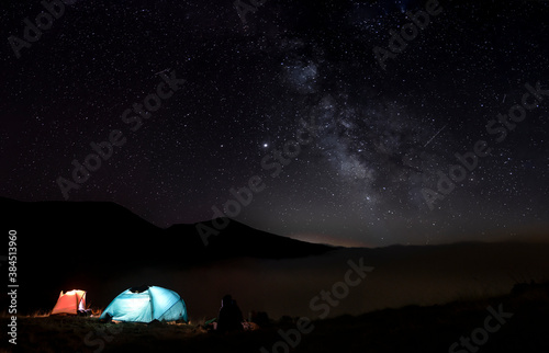 Iluminated tents in the mountains. Starry sky with the milky way in Pajares, Spain. photo