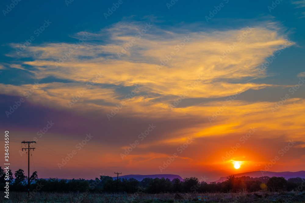 beautiful orange cloudy sunset at the fields 