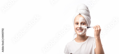 Skin care and spa treatments. Emotional portrait of a positive and cheerful beautiful teen girl with cosmetic mask on her faceon a white background. banner, panorama photo