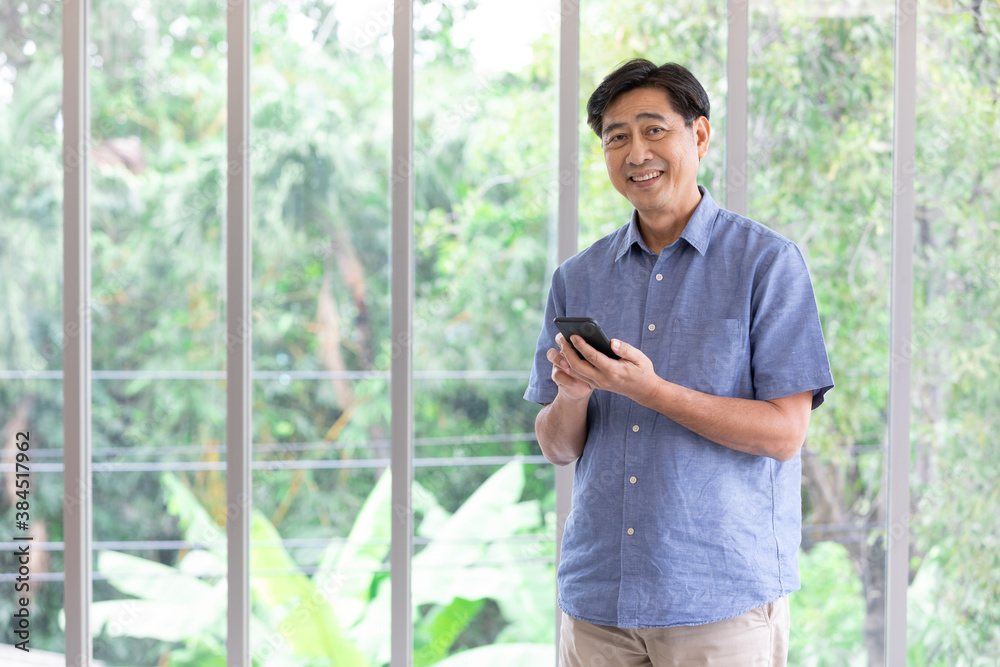 portrait senior asian man holding smartphone at home portrait senior asian man holding smartphone at home