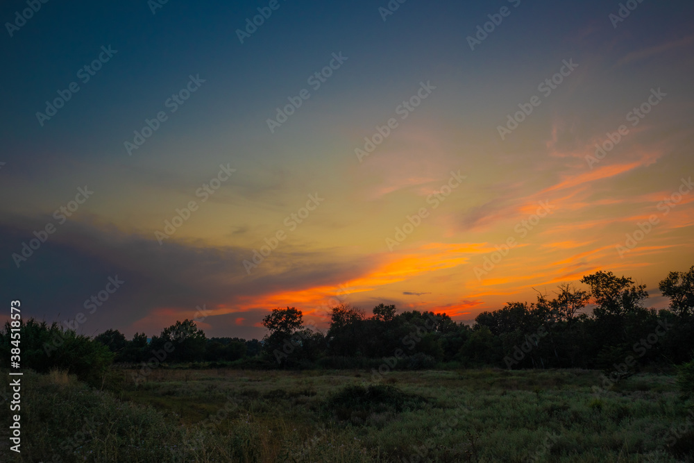 beautiful orange cloudy sunset at the fields 