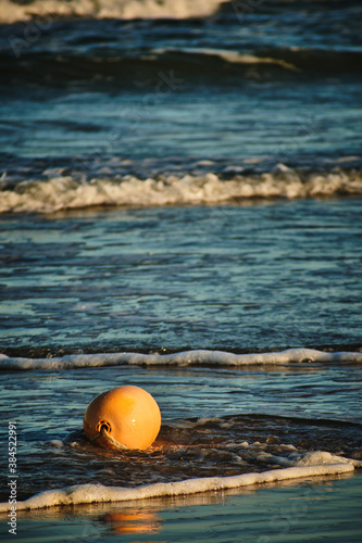 small yellow buoy in water, with small waves behind © Matuxs