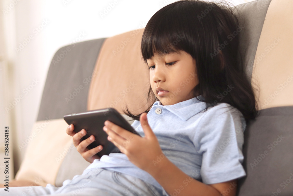 Asian little baby girl plays with gadget smart phone, children with phone addict Asian little baby girl plays with gadget smart phone, children with phone addict