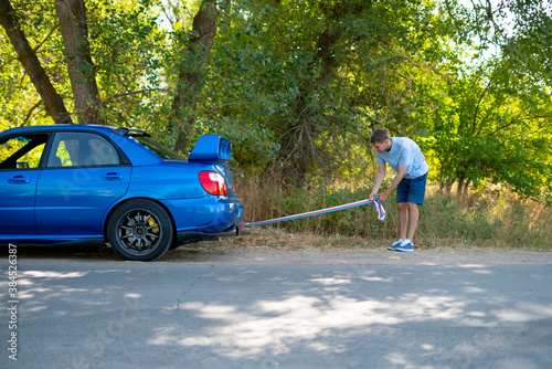 man holding a towing rope and install it on the car hook, the auto accident and problem with engine photo