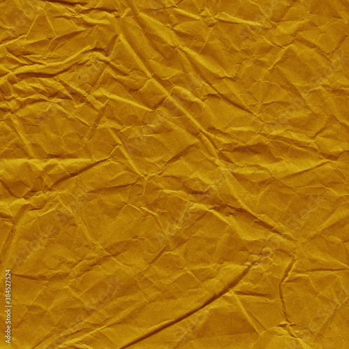 Yellow vintage and old looking crumpled paper background. Retro cardboard texture. Grunge paper for drawing. Ancient book page. Present wrapping.