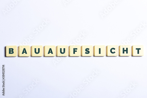 Bauaufsicht in Buchstaben auf Würfel auf weißem Hintergrund